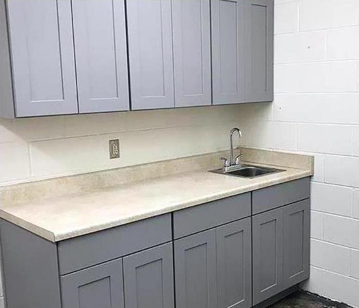Kitchen sink and gray lower cabinets