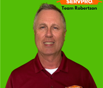 Smiling man on green background with SERVPRO logo