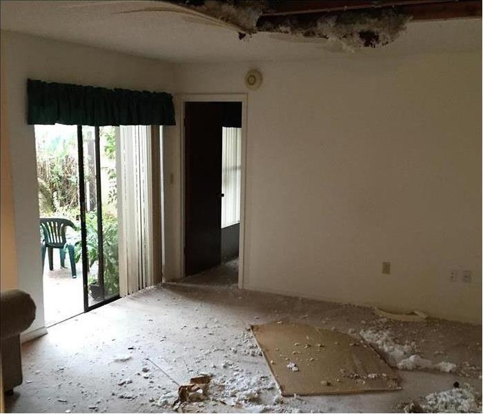 Empty room with collapsed ceiling and drywall on the floor