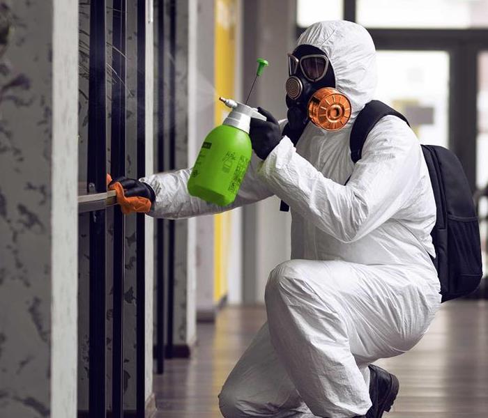 SERVPRO Technician spraying surfaces in a building. 